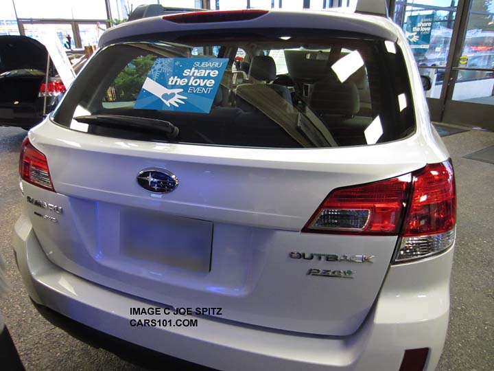 a 2013 share the lover window cling an a new 2014 white Outback on the showroom floor