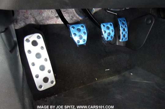 Subaru BRZ metal footrest, gas, brake and clutch pedals. Shown with protective blue plastic as shipped from the factory.