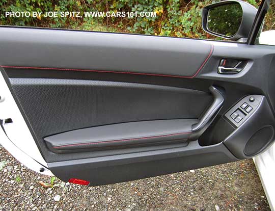 2017 Subaru BRZ Premium driver's door leatherette armrest, pebbled door insert trim, black door grip, red reflector on bottom edge (Limiteds have a courtesy light there).