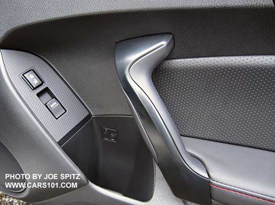 closeup of the 2017 Subaru BRZ Premium passenger door black door grip, leatherette armrest, red stitching, pebbled plastic insert trim.