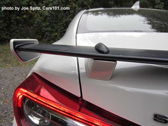 closeup of the 2017 Subaru BRZ black rear spoiler with body colored tips and supports, shown on a crystal white Limited