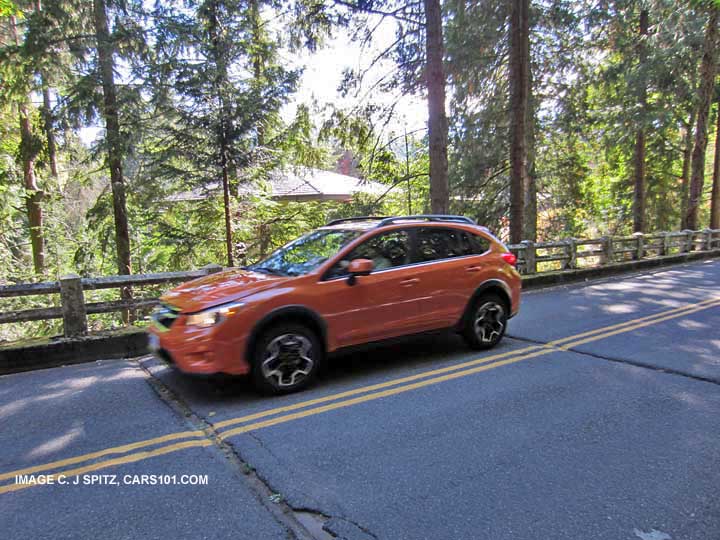 subaru xv crosstrek on a winding road, tangerine orange