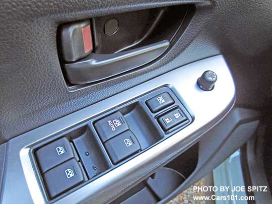 close-up of the 2015 Crosstrek 2.0i base model driver's door interior panel, showing the gray interior door handle and the power window and door lock buttons without the little chrome trim