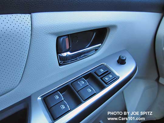 2015 Crosstrek Limited front drivers door panel, warm ivory shown, showing the chrome interior door handle and the power window and door lock buttons with the little chrome trim