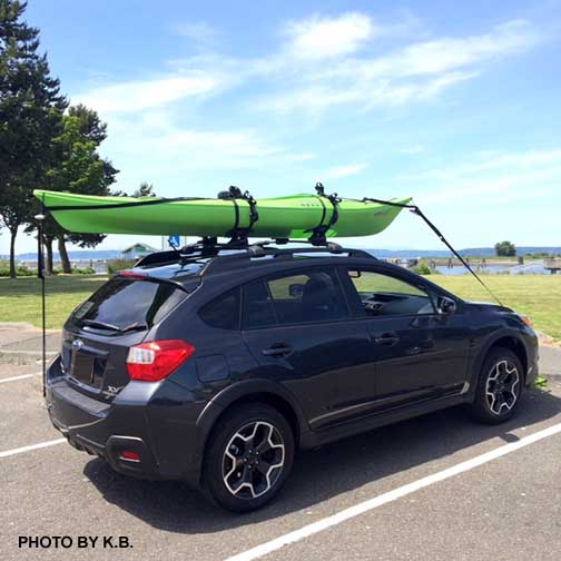 2015 Subaru Crosstrek with a green kayak, using tow hooks to secure it