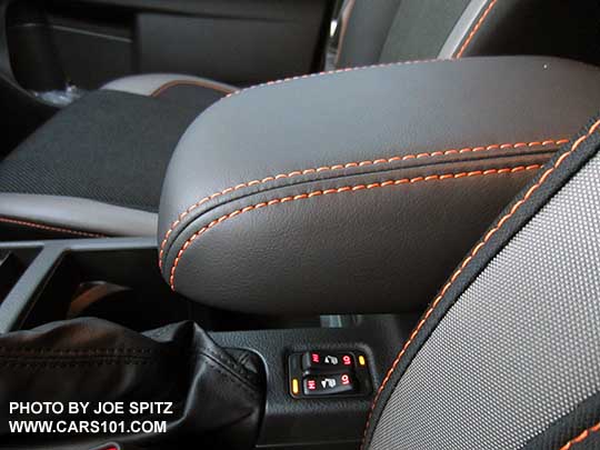 2016 Crosstrek center armrest with orange stitching. The armrest slides forward, shown foreward