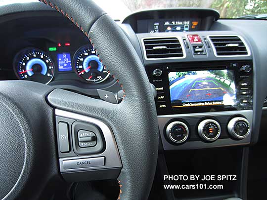 2016 Subaru Crosstrek Hybrid Touring leather wrapped steering wheel w/ orange stitching, , blue dash gauges,  7" audio with rear view backup camera lines showing.