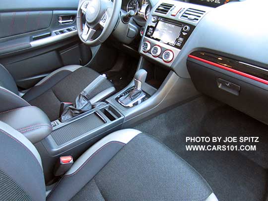 center console of the 2016 Crosstrek Premium Special Edition with retractable cupholder cover shown closed and sliding armrest back. Notice the red/gloss black dash trim.
