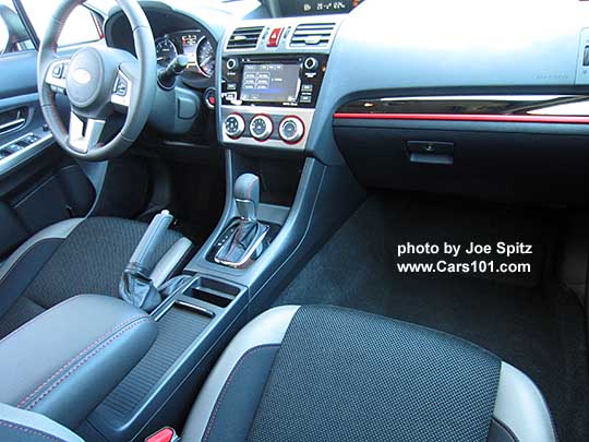 center console of the 2016 Crosstrek Premium Special Edition with retractable cupholder cover shown closed and sliding armrest pushed forward. Note the gloss black/red dash trim