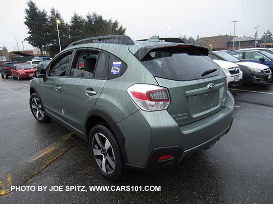 new and side view Subaru Crosstrek Hybrid Touring in the rain. Jasmine Green color, without optional rear bumper cover.