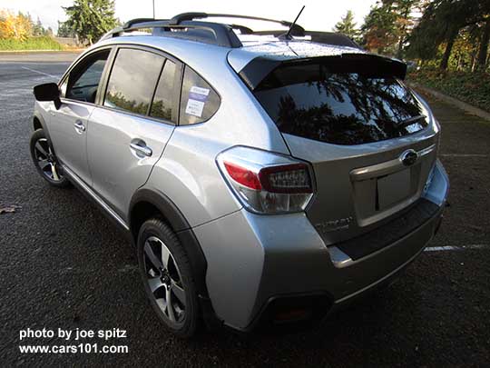 rear side view 2016 Subaru Crosstrek Hybrid Touring, ice silver shown. With optional aero cross bars and rear bumper cover