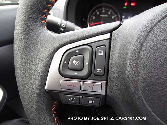 closeup of the bluetooth and audio controls on the  2016 Crosstrek leather wrapped steering wheel with orange stitching