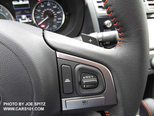 close-up of the Eyesight cruise control buttons on the  2016 Crosstrek leather wrapped steering wheel with orange stitching.