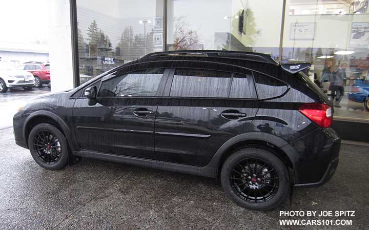 2017 black Subaru Crosstrek with the black STI wheels, black STI rear spoiler, sport mesh grill, side window moldings, aftermarket Rally Armor splash guards... shown wet, it was raining