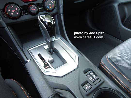 2018 Subaru Crosstrek Premium console with Xmode, heated seat buttons, manual heater/ac controls. The shift knob has a leather wrapped base with silver sides and gloss black upper grip, and a silver shift plate, with D drive and M manual modes. The Premium and Limited models have paddle shifters with 7 'gear settings' for full driver control when needed.