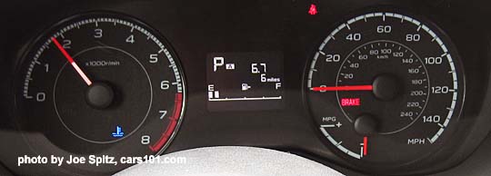 2018 Subaru Crosstrek 2.0i and Premium (without Eyesight upgrade), gauges with white lettering, red gauge needles,  2.4" center dash black and white digital trip computer info display between gauges. Showing blue cold engine light.