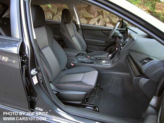 2018 Subaru Crosstrek Premium CVT, silver shift plate, dark carbon fiber-like dash trim, black cloth seats with orange stitching.