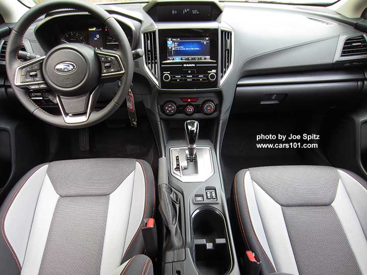 2018 Subaru Crosstrek Premium, light and dark gray cloth seats nd leather wrapped steering wheel with orange stitching, silver shift plate with gloss black shift knob, console with cupholders,  heated seat and Xmode buttons,  manual heat/ac controls, 6.5" audio screen.