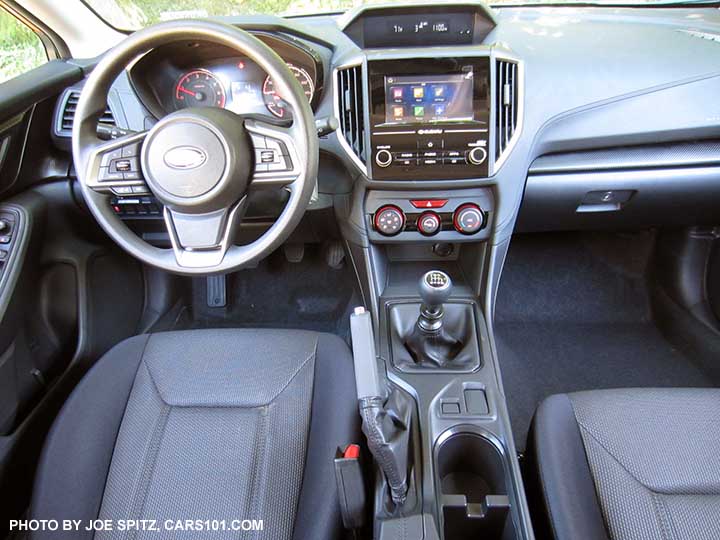 2018 Subaru Crosstrek 2.0i (base model) interior with manual 6speed transmission, gray cloth, black stitching, vinyl covered steering wheel, no heated seat buttons.