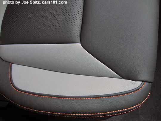 closeup of the 2018 Subaru Crosstrek Limited perforated gray leather seating surfaces with orange stitching and matching leatherette.  Its light gray bolsters with dark gray seating area. Front passenger seat cushion shown.