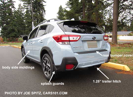 2018 Subaru Crosstrek showing optional body side moldings, splash guards, rear bumper cover, and trailer hitch. Cool gray khaki color shown.