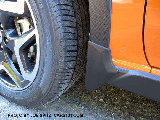 2018 Subaru Crosstrek optional splash guard. Set of 4, left front shown on a sunshine orange car.