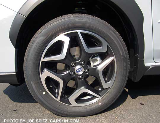 2018 Subaru Crosstrek Limited 18" machined black and silver alloy wheel, on a cool gray khaki color car.