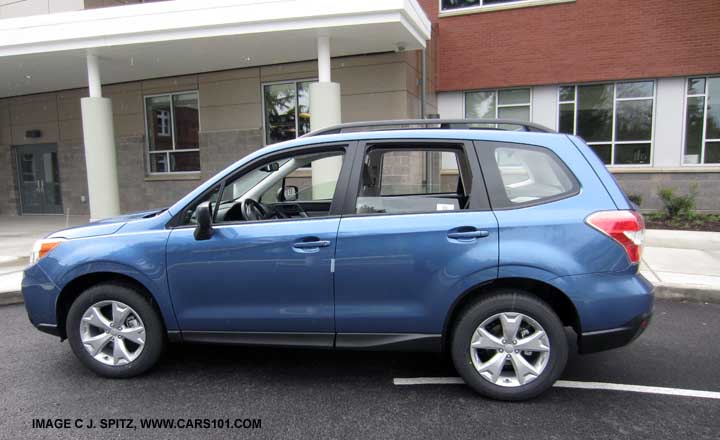 side view 2016 and 2015 Subaru Forester 2.5i with Option Package #02 alloy wheel - roof rack package. Notice the untinted windows.  quartz blue shown