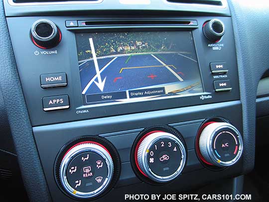 2018 and 2017 Subaru Forester 2.5i base model 6.2" audio screen showing rear view backup camera with white arrow pointing at the onscreen DELAY function.  Manual AC/heater controls with 4 speed fan.