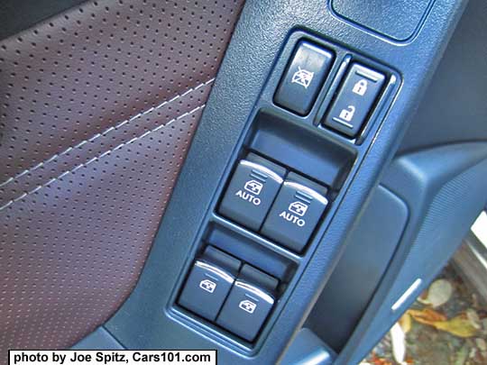 closeup of the 2017 Subaru Forester Touring front door power window and lock switches. Saddle brown perforated leatherette door insert shown.