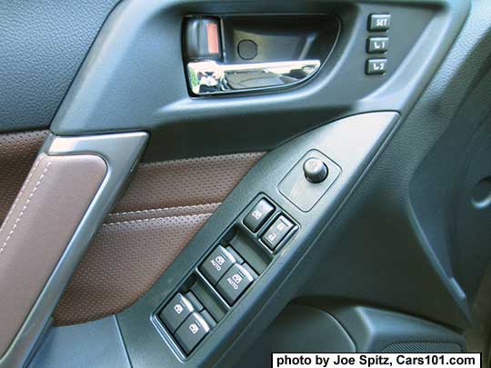 closeup of the 2017 Subaru Forester Touring front door power window and lock switches. Saddle brown perforated leatherette door insert shown.