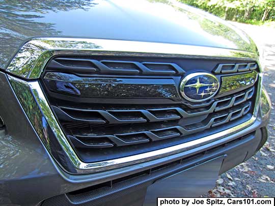 closeup of the 2018 and 2017 Subaru Forester XT model front grill with gloss black center strip and center  Subaru logo on a Sepia Bronze car.