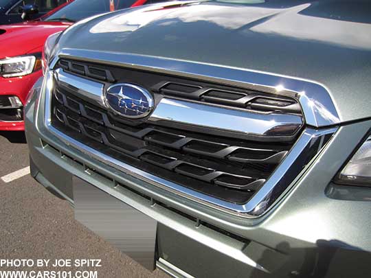 closeup of the 2018 and 2017 jasmine green Forester Limited front grill with chrome strip and Subaru logo