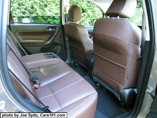 2018 and 2017 Subaru Forester  2.5i and 2.0XT Touring saddle brown leather trimmed rear seat showing the folding armrest with cupholders. Leather models (Limited/Touring) have 2 front seatback map pockets
