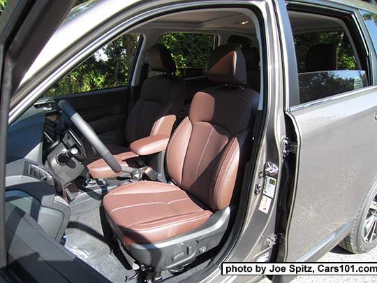 2017 Subaru Forester 2.5i and 2.0XT Touring saddle brown leather front seats in the sun, with center armrest in the forward position. The leather looks different depending on the light. XT model shown (note the XT wheel). Sepia bronze car shown.