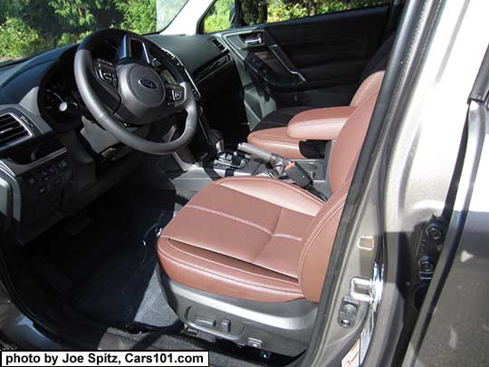2017 Subaru Forester 2.5i and 2.0XT Touring saddle brown leather front seats in the sun, with center armrest in the forward position. The leather looks different depending on the light.