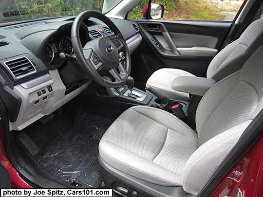 2017 Subaru Forester Premium platinum gray cloth front driver and passenger seat. Silver dash and shift trim.  Armrest slid forward.  Venetian red car shown.