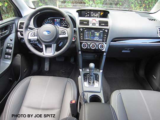 2017 Subaru Forester Touring black leather interior with gloss black dash and shift trim, and leather center console storage trim