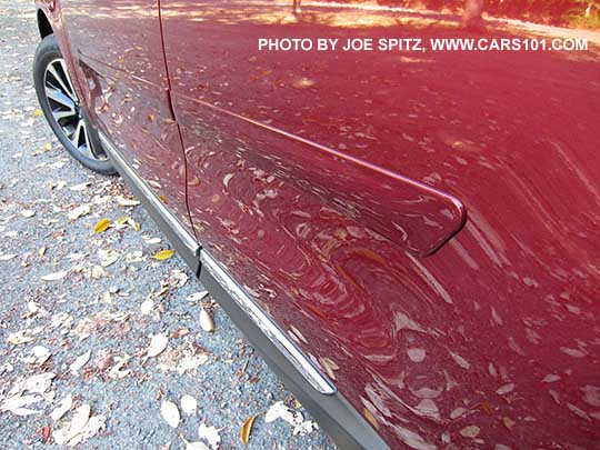 closeup of the 2017 Subaru Forester optional body side moldings, body colored, venetian red car shown