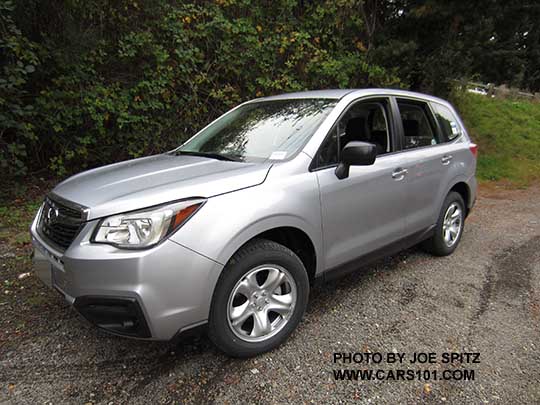 2017 Subaru Forester 2.5i base model, ice silver, has steel wheels, no dark tinted windows, no roof rails, black unpainted outside mirrors
