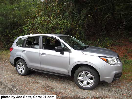 2017 ice silver Subaru Forester 2.5i base model, has steel wheels, no dark tinted windows, no roof rails, black unpainted outside mirrors