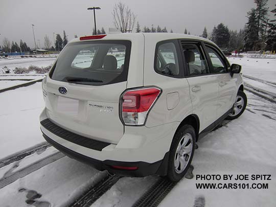 2017 Subaru Forester 2.5i, steel wheels, no dark tinted rear glass, no roof rails. Optional rear bumper cover and splash guards. Color white shown.