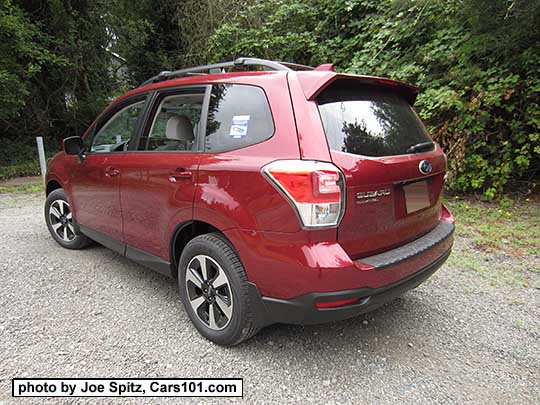 2018 and 2017 Subaru Forester 2.5 Premium with dark tinted rear glass, redesigned 17" black/silver alloys and new for 2017 Premium model rear spoiler. Venetian Red color shown.Optional rear bumper cover, cross bars, and splash gu