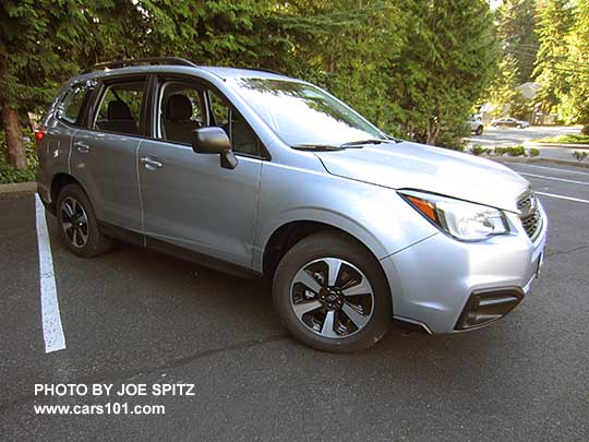 2017 Subaru Forester 2.5 base model has unpainted black outside mirrors, and no dark tinted rear windows or lower chrome fog light trim. Shown with optional Alloy Wheel/Roof Rail Package, Ice silver. Redesigned wheels for 2017