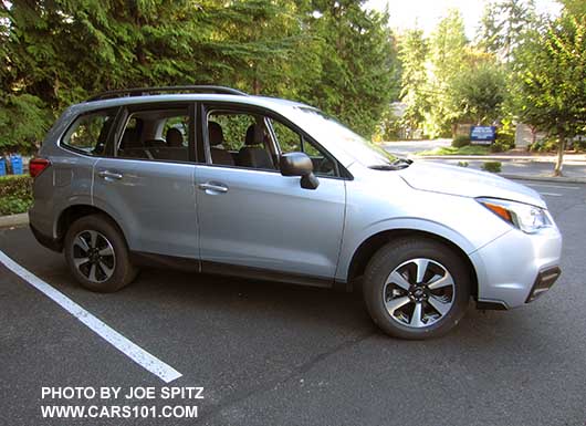 2018 and 2017 Subaru Forester 2.5 base model has black outside mirrors, and no rear spoiler, no dark tinted rear windows, and no lower chrome fog light trim. Shown with optional Alloy Wheel/Roof Rail Package, Ice silver. Redesigned wheels for 2017