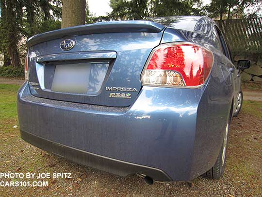 2015 Impreza 2.0i 4 door sedan rear trunk view. Quartz blue shown. Standard trunk lip spoiler, and exhaust without a tailpipe tip.