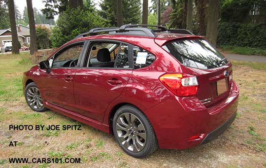 rear view 2015 Impreza Sport 5 door, venetian red color.  All Sports have roof rack rails, gray alloys, turn signal mirrors...
