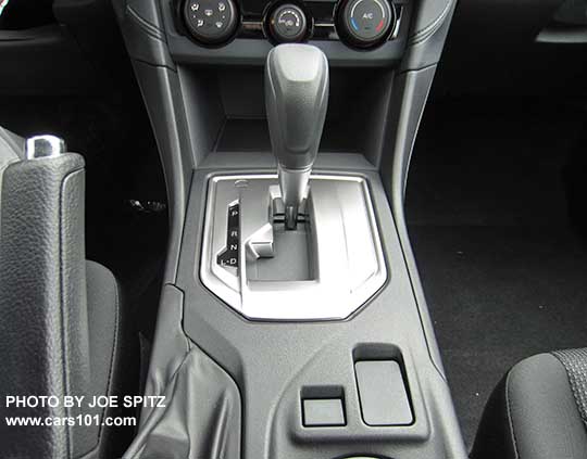 2017 Subaru Impreza 2.0i base model center console with vinyl shift knob, silver shift surround, CVT Drive and Low models only, and blank spot where the heated seat buttons are on all other models.