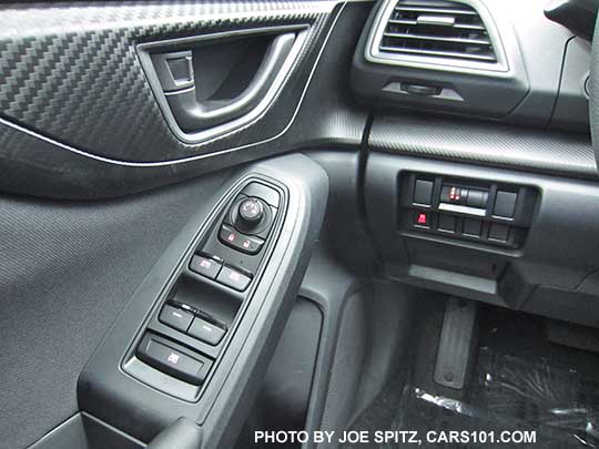 2017 Subaru Impreza  2.0i base model driver's door power window buttons, mirror joystick, black door handle. Black cloth shown