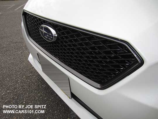 closeup of the 2017 Subaru Impreza optional front Sport Mesh Grill, with center Pleaides logo showing on a crystal white Limited 4 door sedan